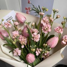 a bouquet of pink flowers in a white box