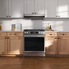 a stove top oven sitting inside of a kitchen next to wooden cabinets and cupboards