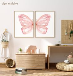 two pink butterfly paintings hanging on the wall above a dresser in a room with white walls