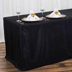 the table is set with two wine glasses and place settings on it, ready to be served