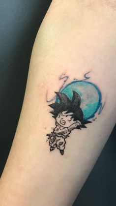 a small tattoo on the arm of a person with a blue moon in the background