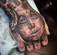 a woman's hand with a skull and rose tattoo on it