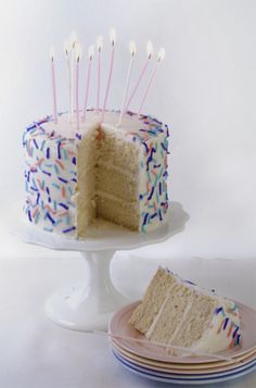 a cake with white frosting and sprinkles is cut from the plate