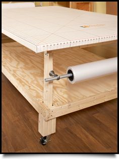 a white table with wheels on it sitting on a hard wood floor