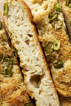 two pieces of bread with green peppers and cheese on top, sitting on a plate