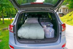 the back end of a car with its trunk open and luggage in it's trunk