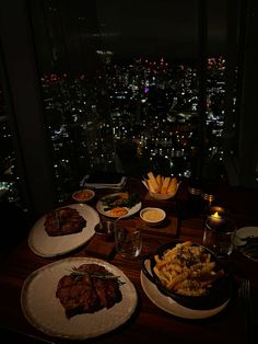 a table topped with plates of food next to a window