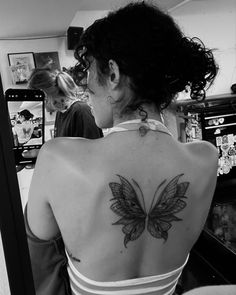 a woman with a butterfly tattoo on her back