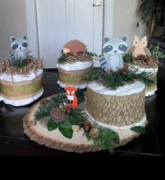 three cakes decorated with woodland animals and pine cones