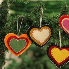 three heart shaped ornaments hanging from a tree