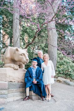 a family poses for a photo in front of a lion statue