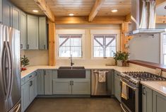 a kitchen with stainless steel appliances and wooden ceiling