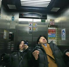 two people standing next to each other in an elevator