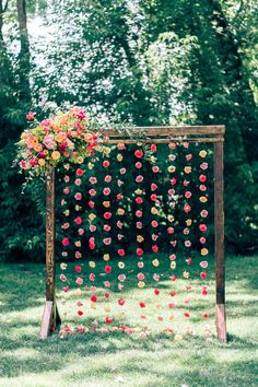 a wooden frame with flowers on it in the grass