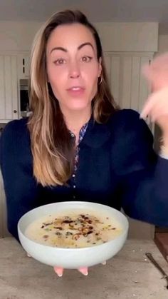 a woman pointing at a bowl of soup