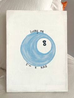 a white canvas with a blue pool ball on it and the words lucky me 8 i'm a kws