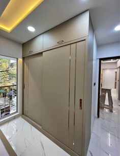 an empty room with sliding doors and white marble flooring in front of a large window