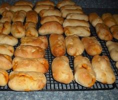 bread rolls are lined up on a cooling rack