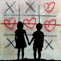 two children holding hands in front of a wall with hearts painted on it and crosses