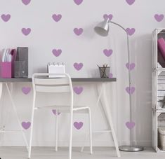 a desk with a chair and some pink hearts on the wall