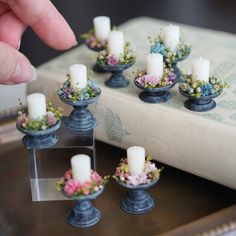 small candles are placed in blue vases with flowers on them