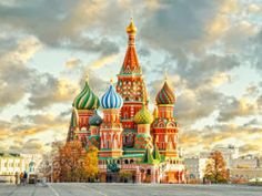 an image of a colorful building in the middle of the day with clouds above it