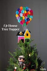 a small christmas tree is decorated with colorful balloons and houses, as well as the words up house tree topper