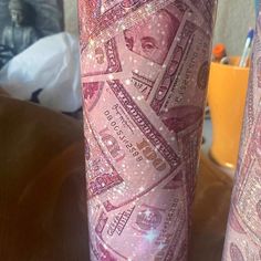 two pink vases with money printed on them sitting on a table next to each other