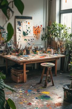 an artist's studio with lots of paint and plants