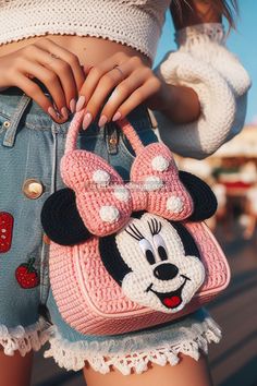 a close up of a person holding a purse with a minnie mouse design on it