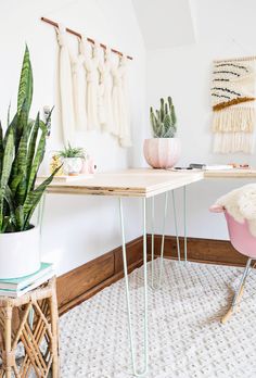 a desk with some plants on top of it and a chair in front of it