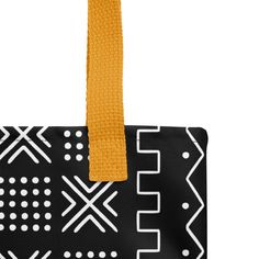 a black and white bag with an orange strap hanging from the front, on a white background