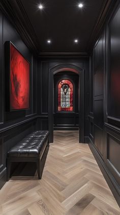 an empty hallway with black walls and wood flooring