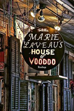 a sign hanging from the side of a building that says marquee aveaus house voodoo