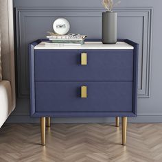 a blue and white nightstand with two drawers on it next to a couch in a room