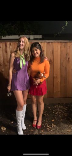 two women dressed in costumes posing for the camera with their hands on their hipss