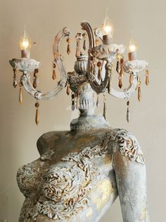 an ornate chandelier hanging from the ceiling in a room with white walls and flooring