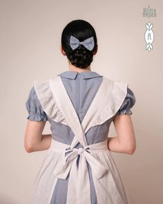 the back of a woman's dress with a bow in her hair