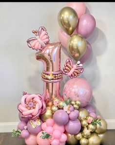 a pink and gold balloon arrangement with balloons