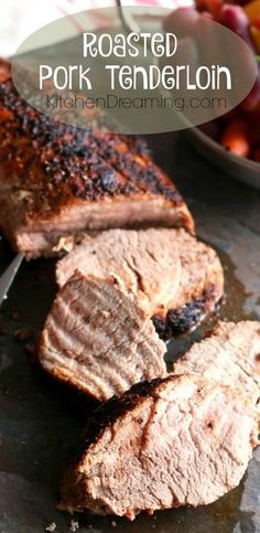 roasted pork tenderloin on a cutting board with fruit in the background and text overlay that reads roasted pork tenderloin