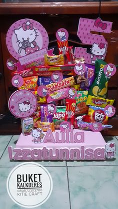 a hello kitty birthday cake with lots of candy and candies on it's stand