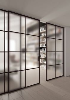 an empty room with sliding glass doors and bookshelves on the wall in front of it