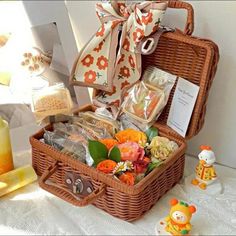 a wicker basket filled with lots of food and candy sitting on top of a table