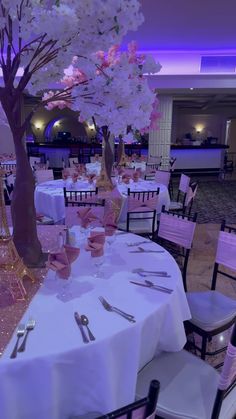 the tables are set with silverware and pink flowers