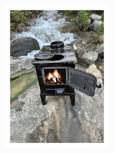 a stove sitting on top of a rock next to a river