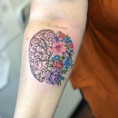 a person with a tattoo on their arm has a flowered brain and flowers in the shape of a heart