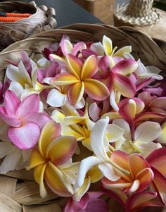 a basket filled with lots of pink and yellow flowers