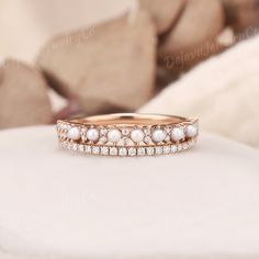 an image of a wedding ring with pearls on the bottom and diamonds in the middle