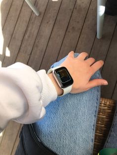 a person with their hand on the wrist of an apple watch that is sitting on someone's lap