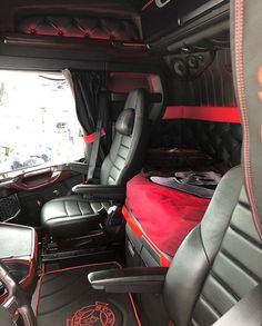 the interior of a vehicle with black leather seats and red carpeting on the floor